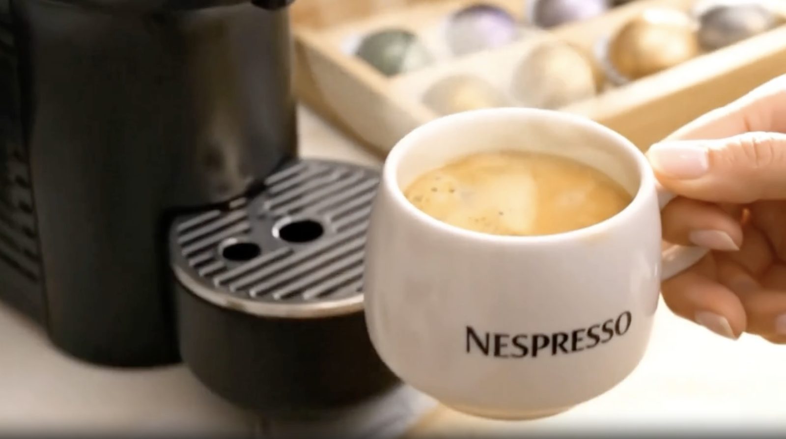 A Nespresso coffee, lit as the anchor of the brand's ritual.