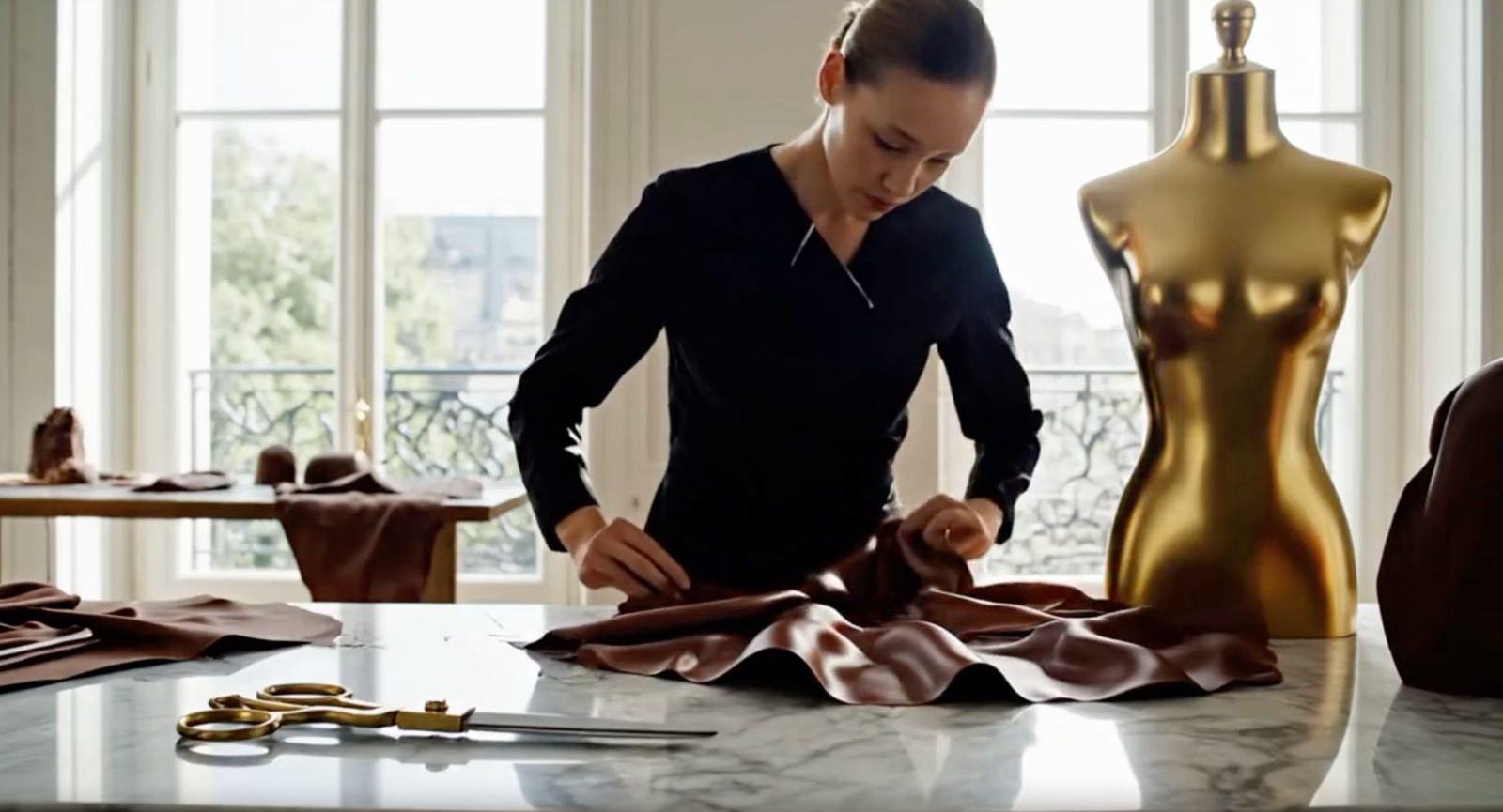 A designer working chocolate 'fabric' at a marble bench.