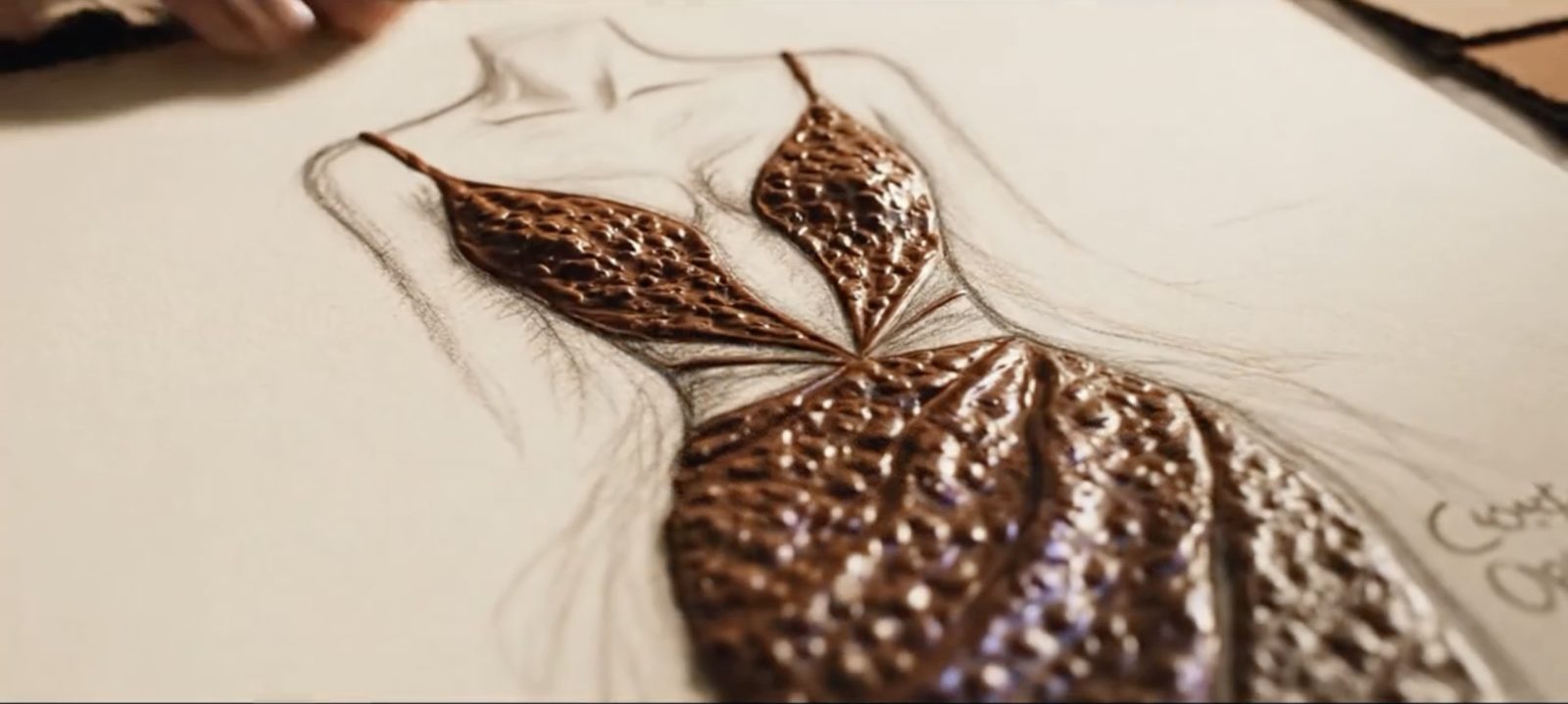 A couture gown rendered in glossy, sculpted chocolate.