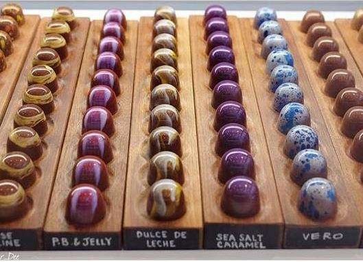 Chocolate creams arranged in rows, each colour-matched to a Nespresso pod.
